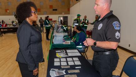 Asm. McKinnor speaks with Hawthorne police officer at display table