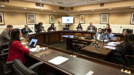 Wide view of the committee, and testimony being given