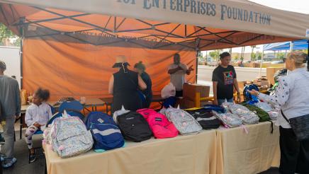 Backpacks displayed on tables at the 101 Enterprises Foundation booth