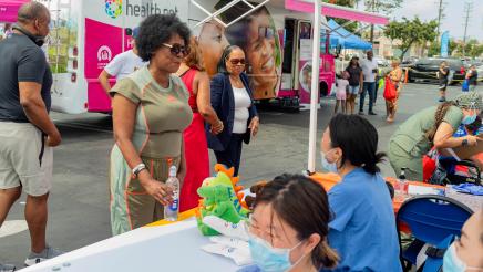 Asm. McKinnor speaking with staffer at dental health booth