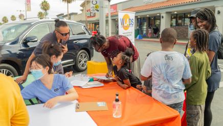 Family at resource booth, signing up for services