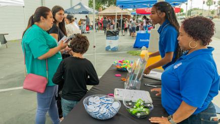 Family speaking with resource booth staffers