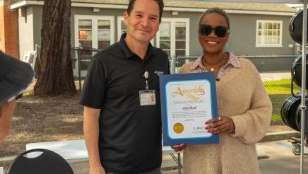 Asm. McKinnor presenting an award to AltaMed staffer