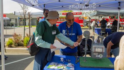SoCalGas staffer in discussion with attendee about gas meter