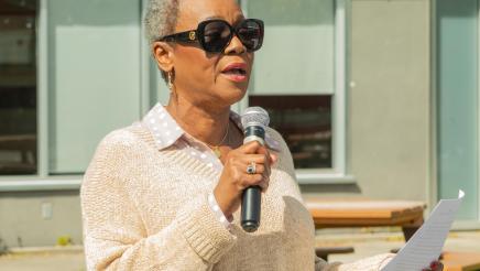 Asm. McKinnor holding microphone, speaking