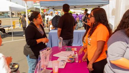 Booth volunteers sharing information with constituent