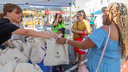 Booth staffer handing gift bag to constituent