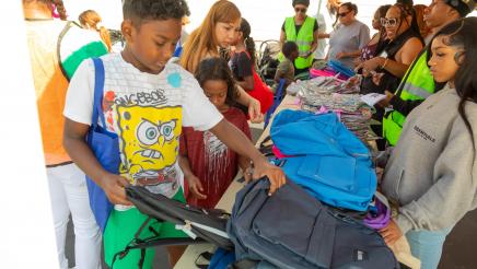 Students being given backpacks