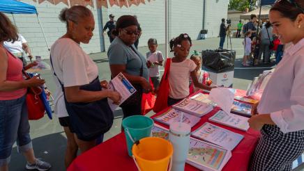 Booth volunteer providing resource materials to constituents