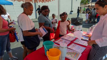 Booth volunteer providing resource materials to constituents