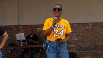 Asm. McKinnor holding microphone and speaking