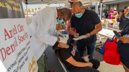 Dental booth volunteers providing free dental services to child