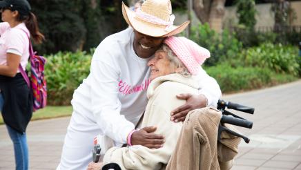 Rally attendee hugging senior woman in wheelchair