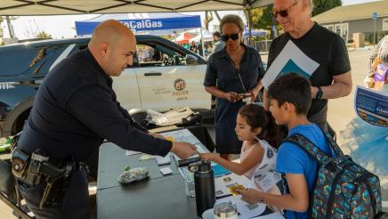 Police officer handing materials to young children