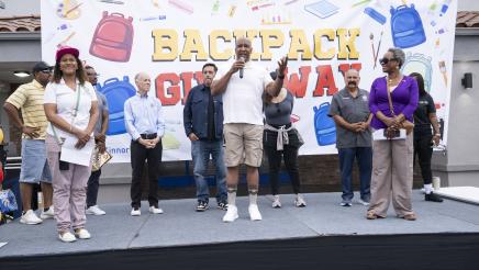 Mayor Butts onstage, speaking as others listen on