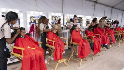 Multiple youths seated, receiving haircuts