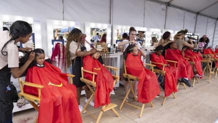 Multiple youths seated, receiving haircuts